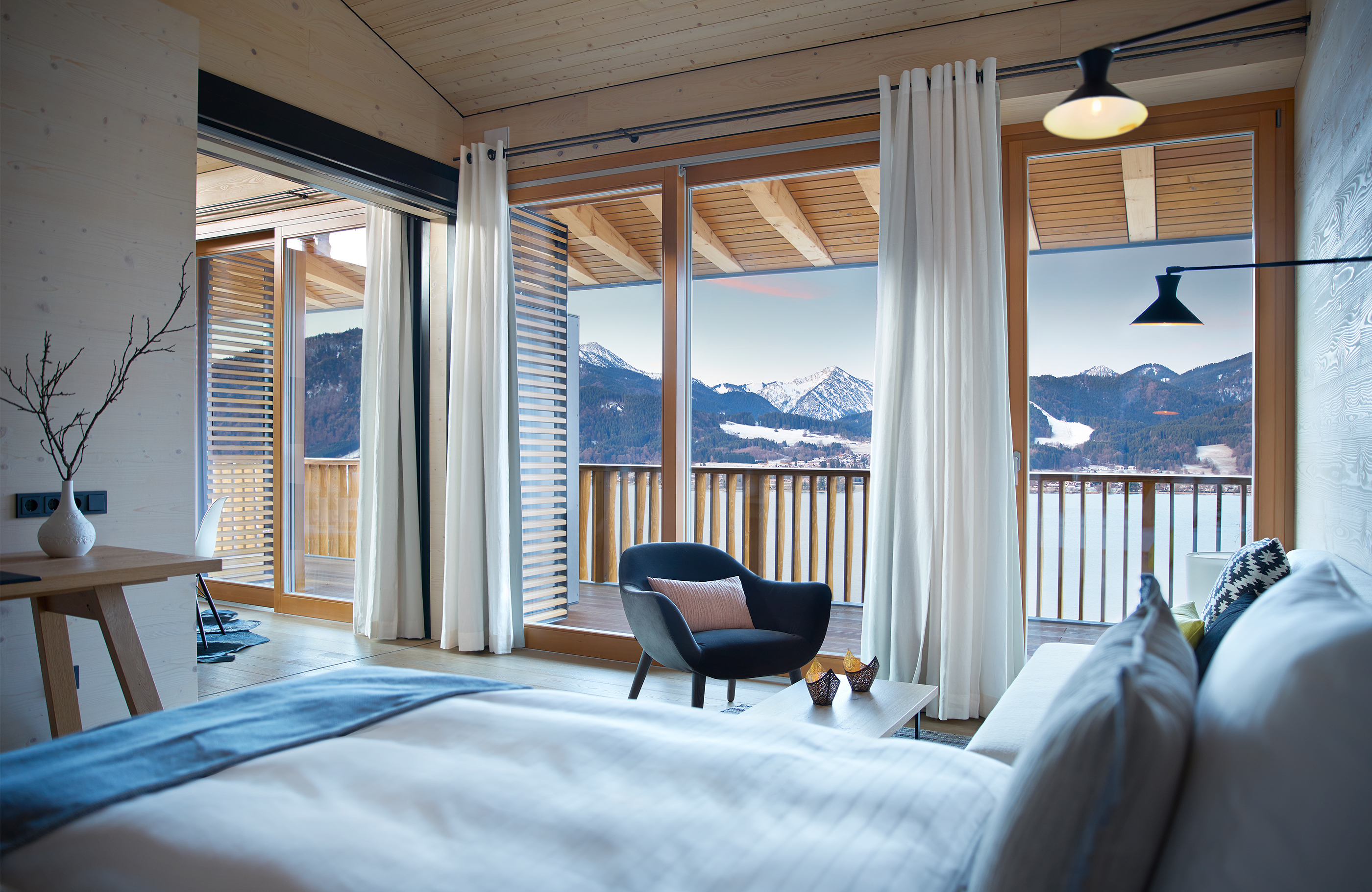 Aufnahme im Schlafzimmer des Alpenchalets mit Blick in die Berge und über den See