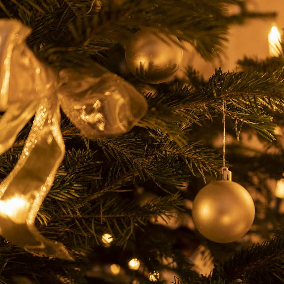 Detail eines Weihnachtsbaumes mit goldenen Weihnachtskugeln